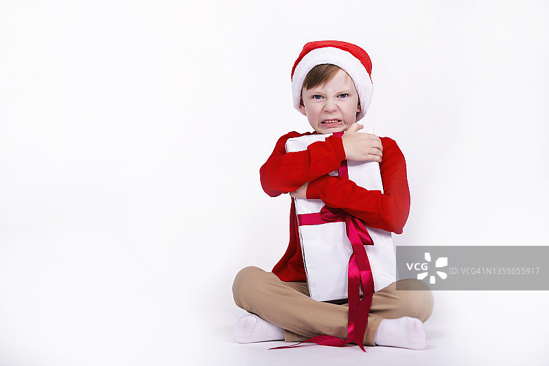 肖像的美丽可爱的男孩穿着圣诞帽在白色的背景图片素材