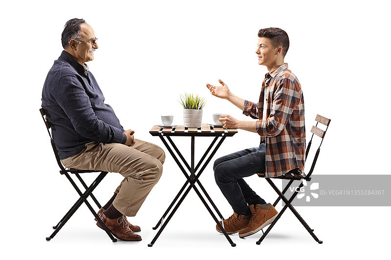 一个年轻人坐在咖啡馆里和一个成熟的男人聊天图片素材