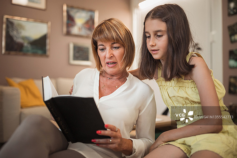 成熟的女人为她的孙女读书图片素材