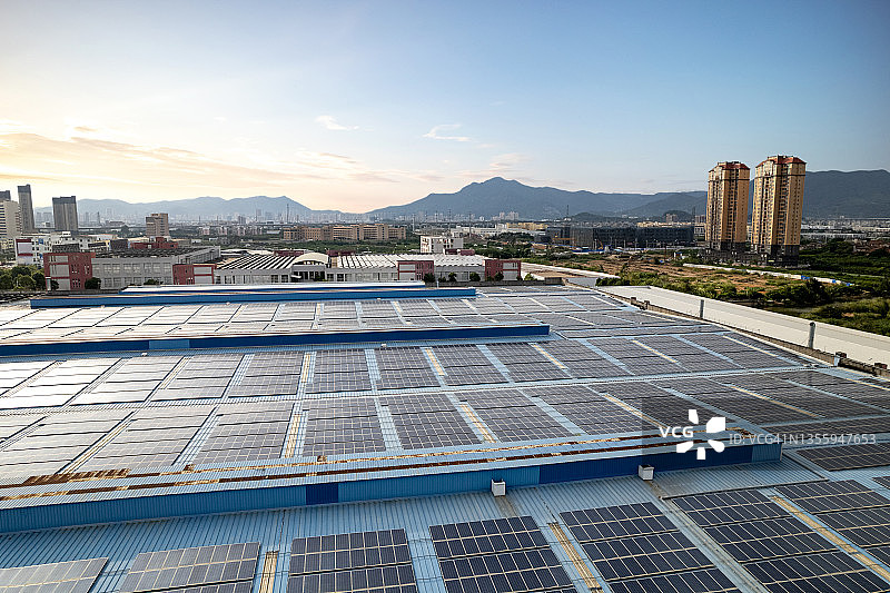 黄昏时在工厂屋顶上壮观的太阳能发电厂的鸟瞰图图片素材