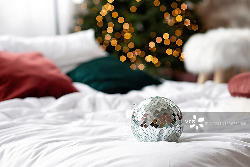 新年的背景。镜面球映衬着圣诞树上的彩灯。软选择聚焦。图片素材
