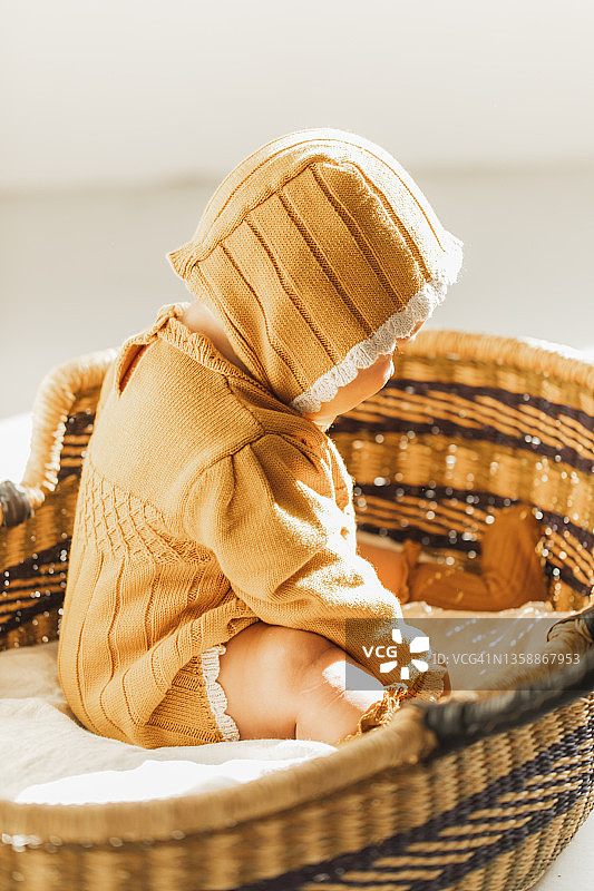 可爱的婴儿醒来在他的草摩西篮子。图片素材
