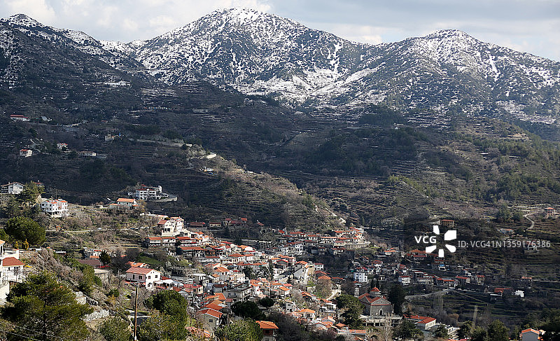 全景真实的乡村村庄在雪山背景图片素材
