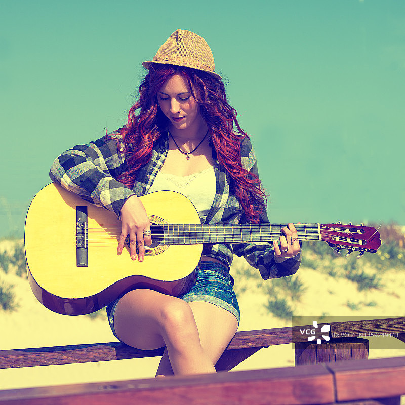 在沙滩上弹吉他的女人图片素材