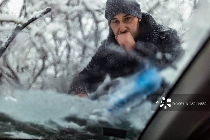 年轻人用冰块清洗汽车玻璃图片素材