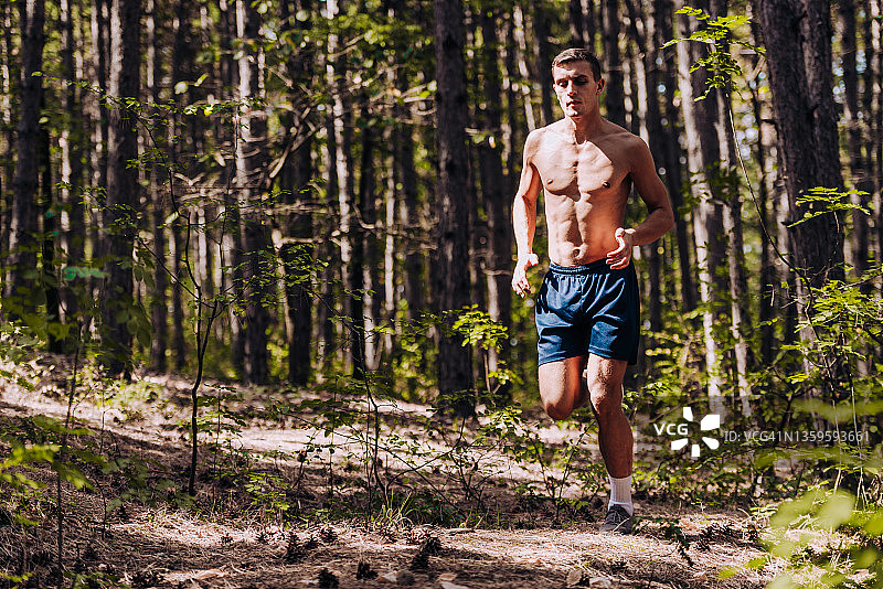 一个健康的男人在户外的山路上奔跑的全身画像图片素材