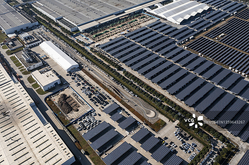 鸟瞰图安装在工厂屋顶和停车场的太阳能电池板图片素材