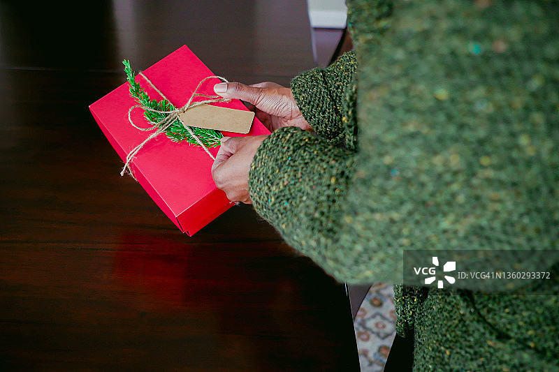 最后的礼物:女人在为圣诞礼物做最后的修饰图片素材