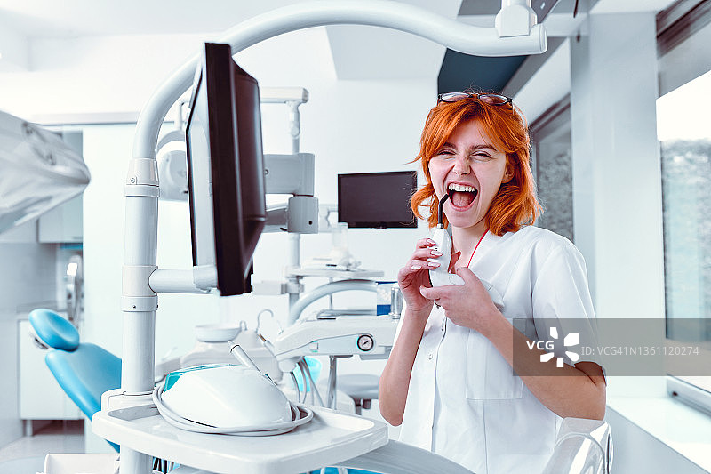 有趣的女牙医在诊所玩治疗光图片素材