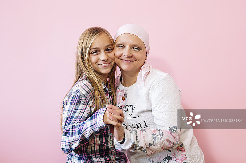 一位身患癌症的妇女坐在她女儿的旁边。一个女孩抱着一个女人开心图片素材