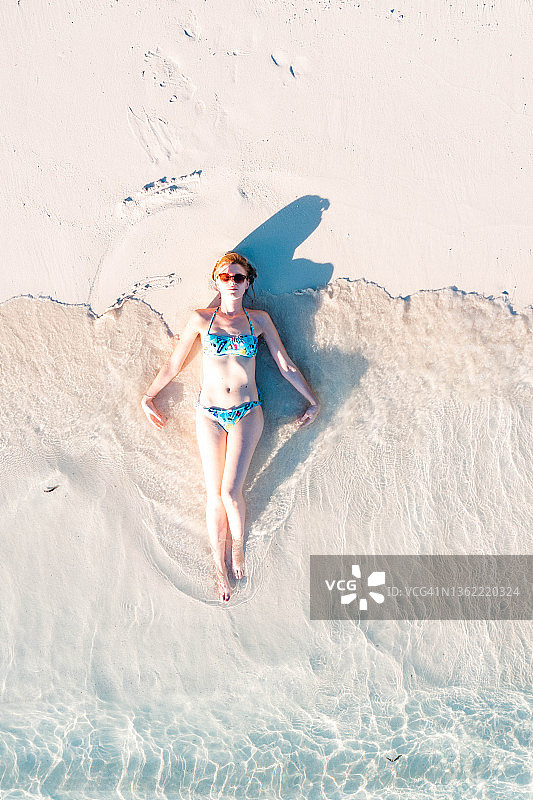 躺在白色沙滩上的女人图片素材