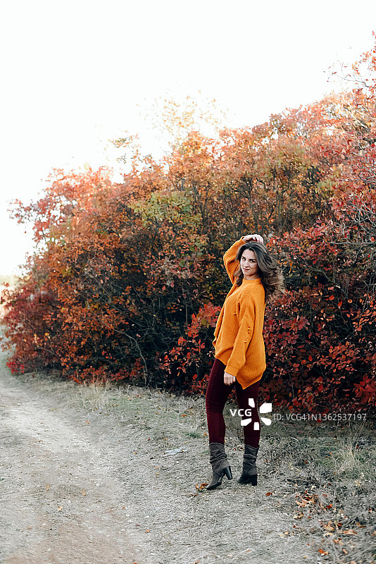 一个女孩的肖像与松散的头发在秋天的自然背景。秋天的气氛。休闲风格。图片素材
