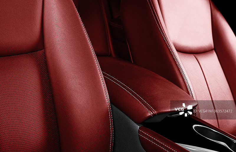豪华车红色皮革内饰。部分皮革汽车座椅的细节与拼接。舒适的红色穿孔真皮座椅。红色的穿孔皮革。汽车内部图片素材