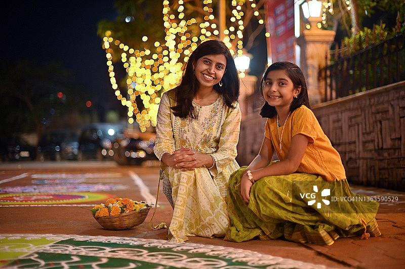 母女俩坐在一幅Rangoli的画旁图片素材