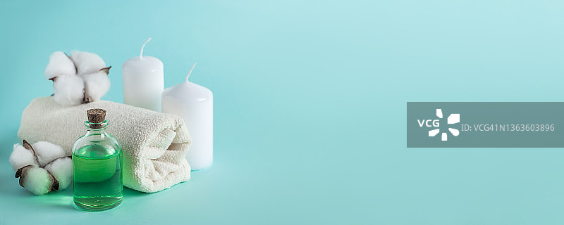 天然有机美容产品，用于水疗和芳香疗法。芳香的精油，蜡烛和一条毛巾在蓝色的背景上。放松的概念图片素材