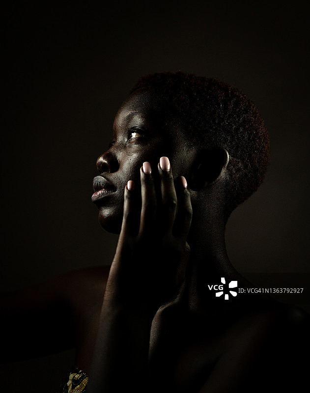 黑色的非洲黑美人侧面与手在脸颊上图片素材