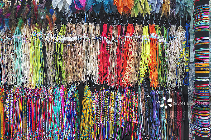 巴西街头小摊上的彩色编织手镯、羽毛耳环和脚踝包图片素材