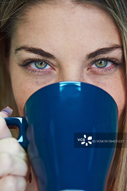 一个女人喝咖啡的特写镜头。图片素材