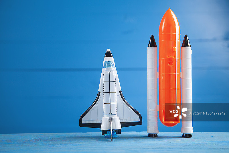 蓝色背景上的玩具航天飞机。火箭发射图片素材