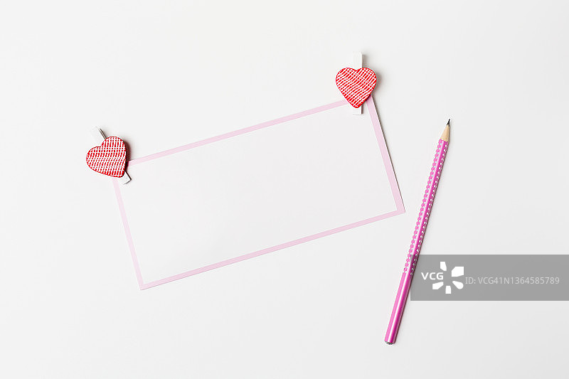 浪漫的信，白色空白贺卡，粉色铅笔和心形装饰在白色的背景上图片素材