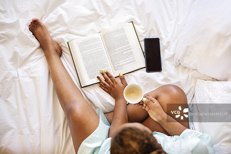 女人早上躺在床上看书喝咖啡图片素材