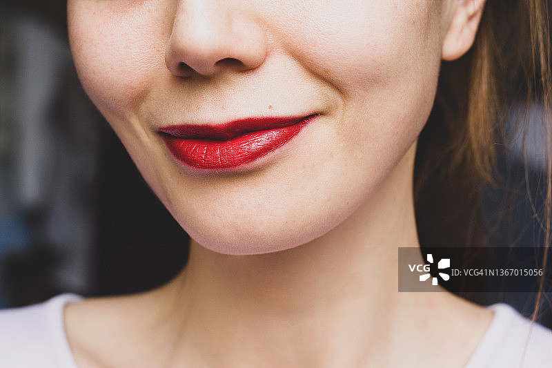 女性鼻子和嘴/嘴唇的特写，涂上红色唇膏图片素材