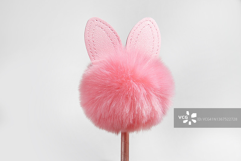 粉红色的复活节兔子皮草剪影，在粉红色的棍子上，孤立在白色的背景上。纪念品，复活节装饰。复活节的概念。本空间图片素材