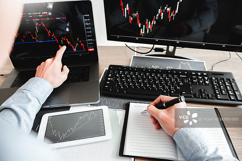 商人投资和企业家交易股票市场和交易所讨论和分析图表。图片素材