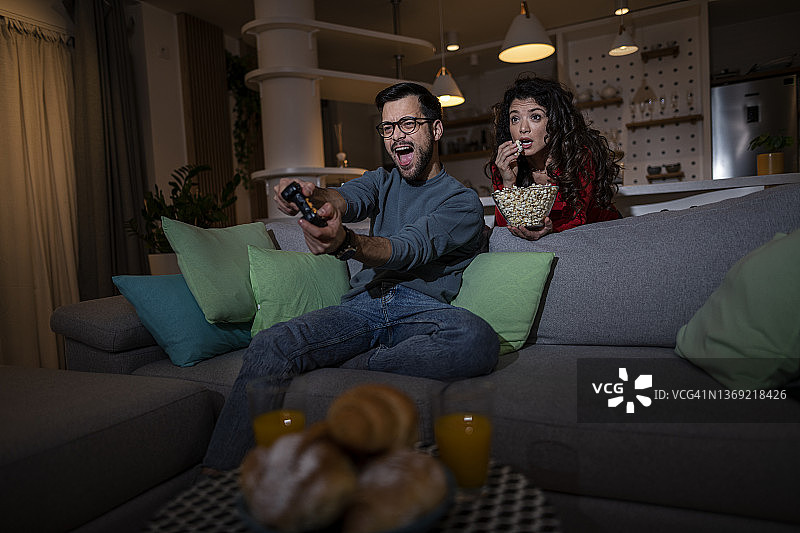 竞争激烈的年轻夫妇在客厅玩电子游戏图片素材