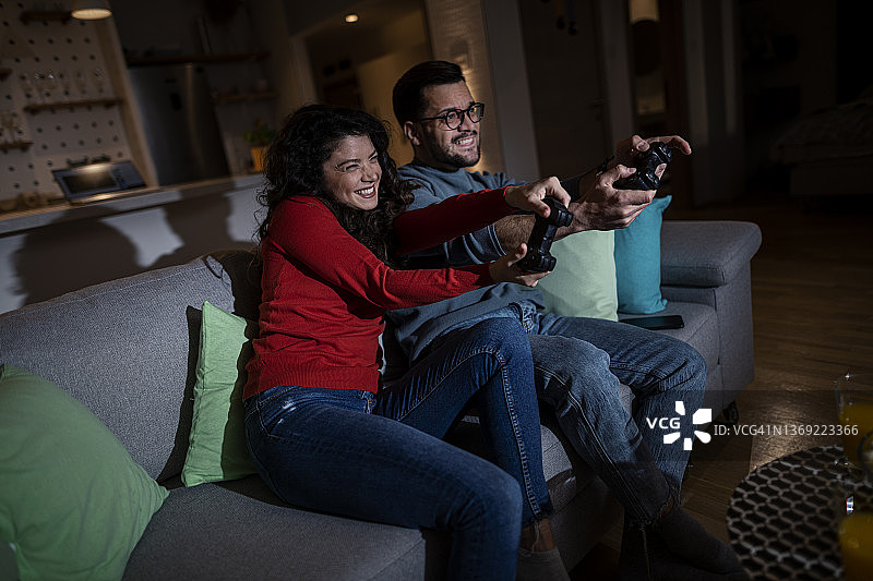 竞争激烈的年轻夫妇在客厅玩电子游戏图片素材