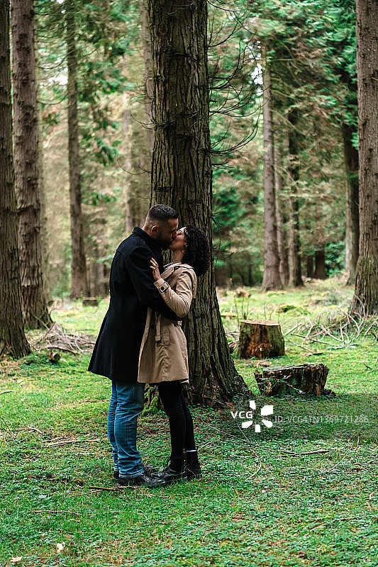 一对情侣站在森林里亲吻图片素材