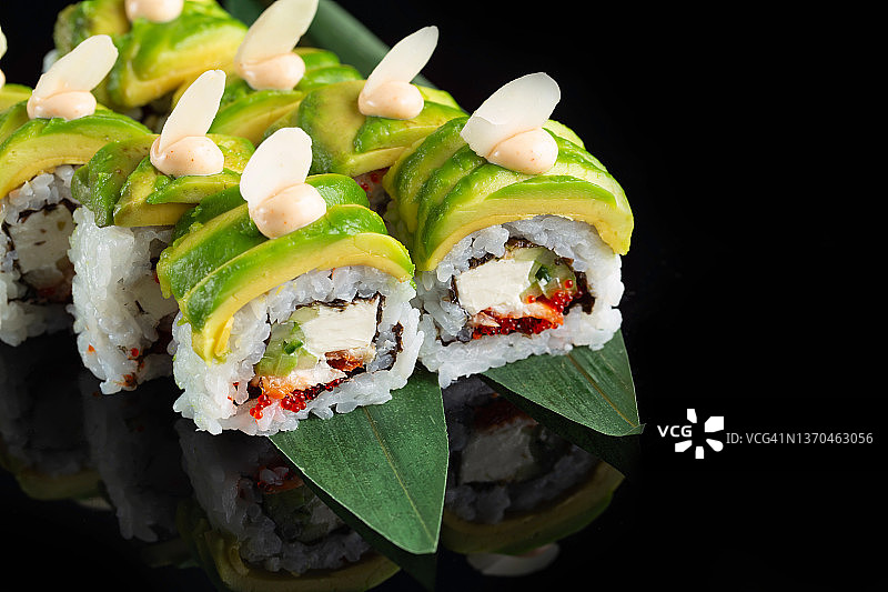 传统美味新鲜的寿司卷设置在黑色背景与反射。寿司卷配米饭，海苔，奶油芝士，鱼子酱，鳄梨。寿司菜单。日本厨房。亚洲餐厅。图片素材