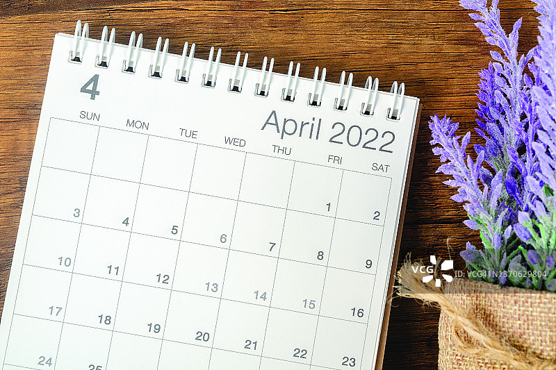 俯视图挂历台2022年4月是组织者在木桌背景上规划和提醒的月份。商业计划预约会议概念图片素材
