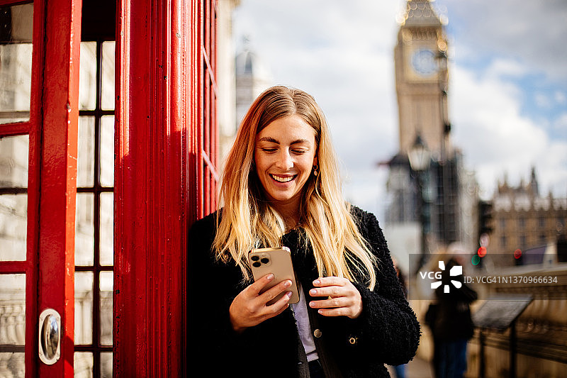 年轻美丽的女子在伦敦街头使用手机图片素材