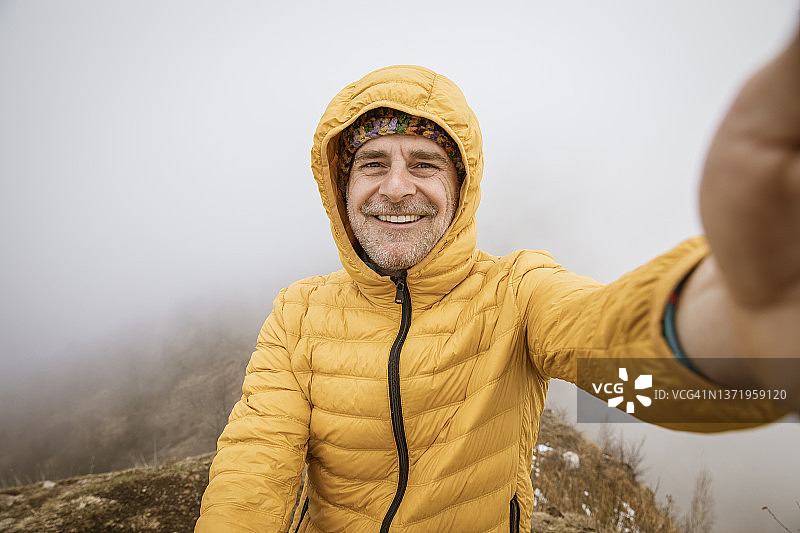 快乐的人带着微笑在山上自拍图片素材