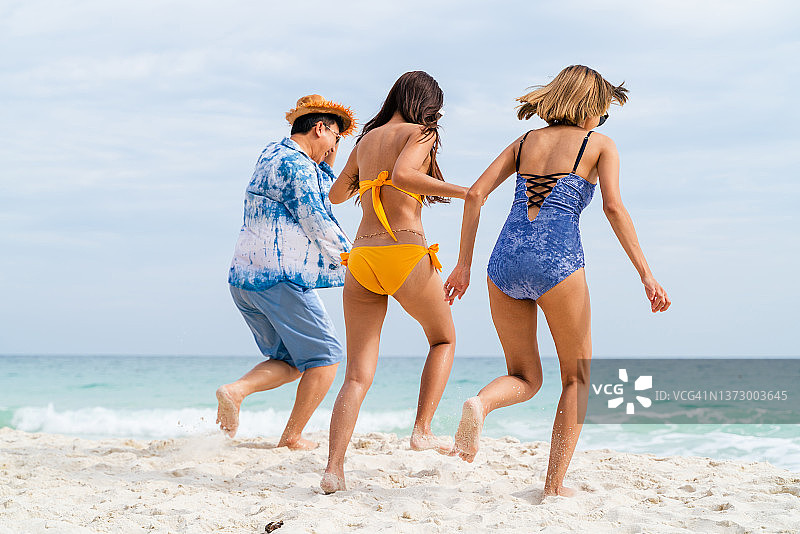 一群兴高采烈的亚洲游客在海滩上享受海滩假日图片素材