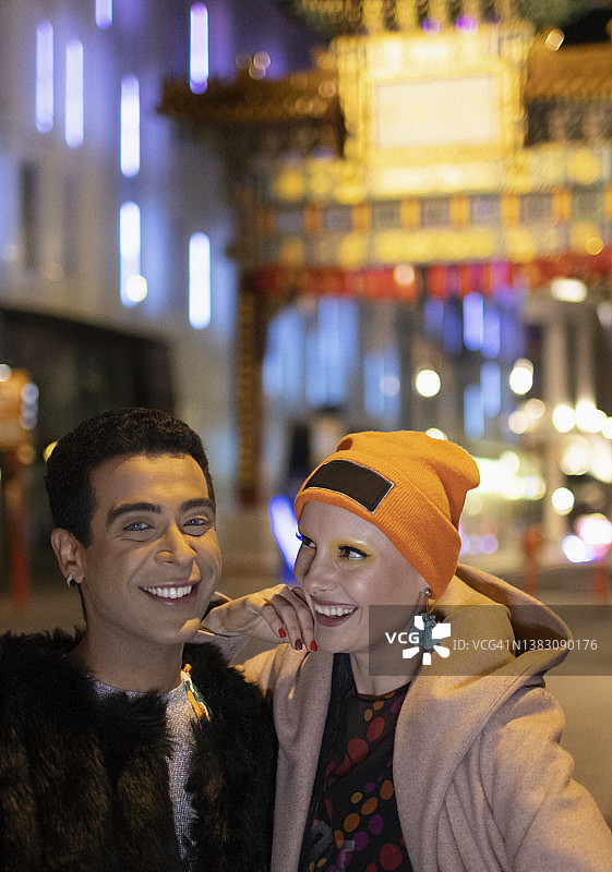 肖像快乐时尚夫妇在唐人街门在晚上，伦敦，英国图片素材
