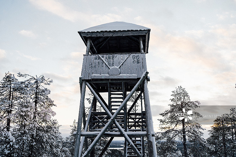 冬季日落时的木制瞭望塔覆霜。图片素材