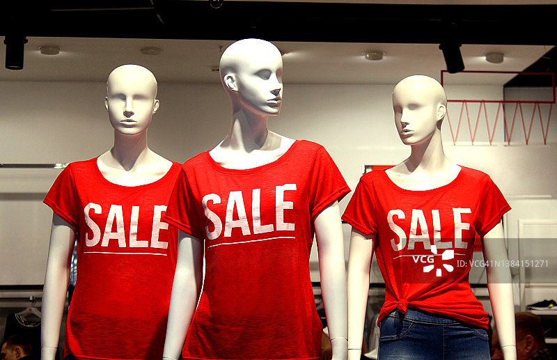 店里有三个人体模型，t恤上写着“销售”的字样。图片素材