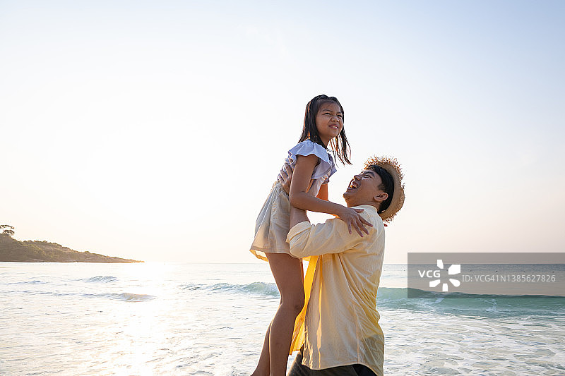 顽皮的父亲和女儿在海滩上图片素材