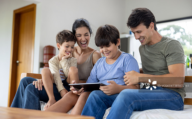 快乐的家庭，在家里玩平板电脑看视频图片素材