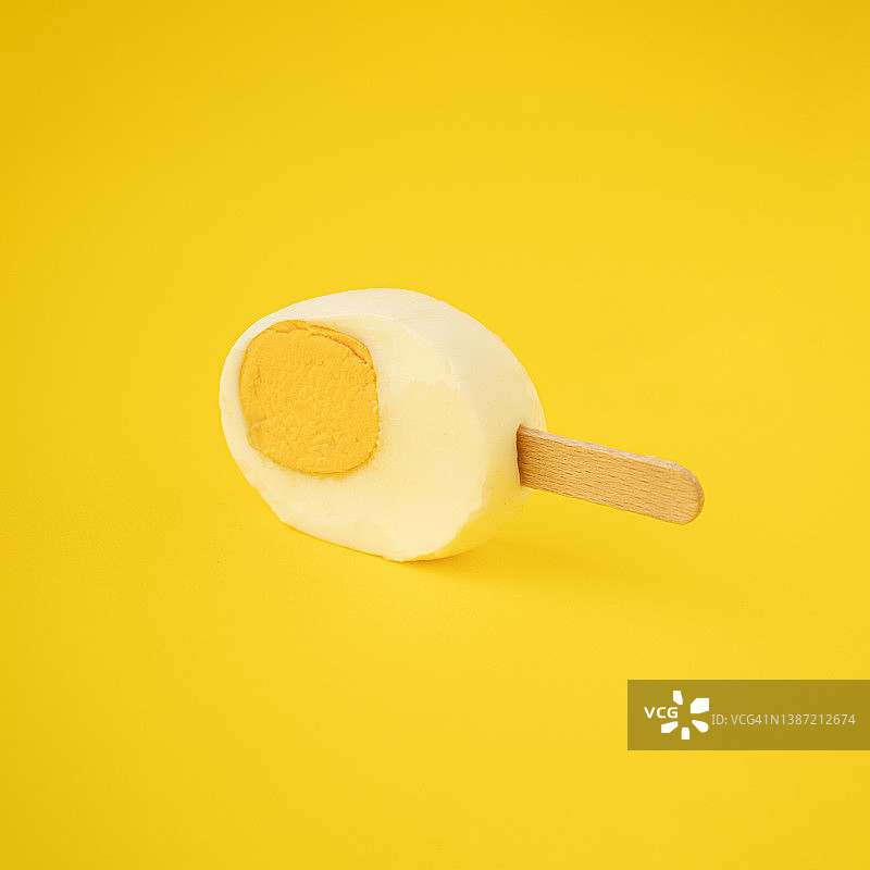 新鲜切复活节彩蛋与冰淇淋棒在黄色背景图片素材