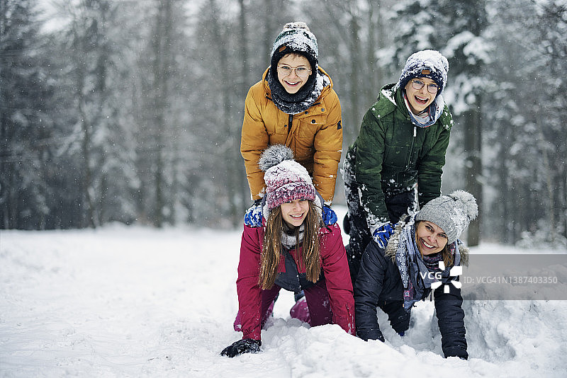 冬天的一天，一家人在美丽的森林里玩雪图片素材