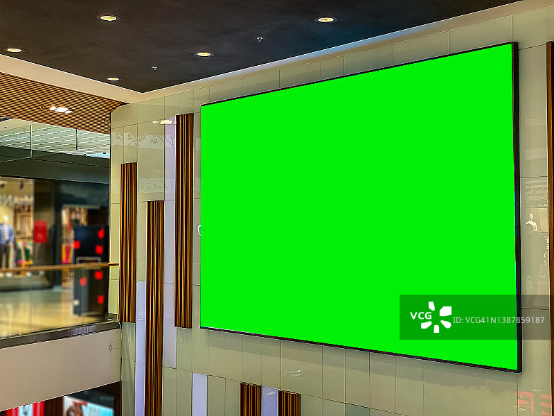 中型绿屏色度关键营销广告广告牌在市中心购物中心，火车站或机场环境，针对消费者，零售购物者，通勤者和游客的广告。图片素材