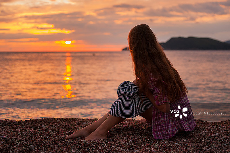 年轻女子比基尼游客在海滩上看日落在海滩图片素材