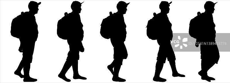 背着背包的游客一个接一个地走着。一群徒步游客。一个戴着运动帽，背着背包，穿着短裤的女人。一位年长的妇女正在徒步旅行。徒步旅行。侧视图,概要文件。图片素材