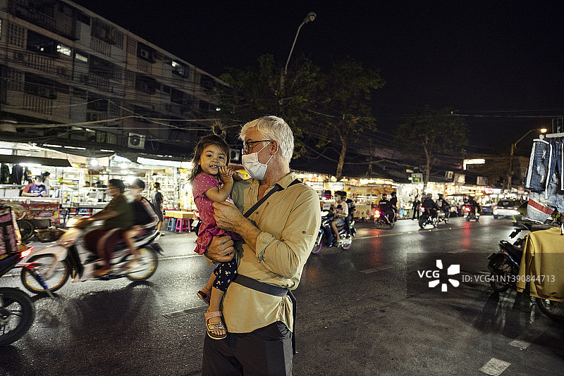晚上爷爷抱着孙女在街上图片素材