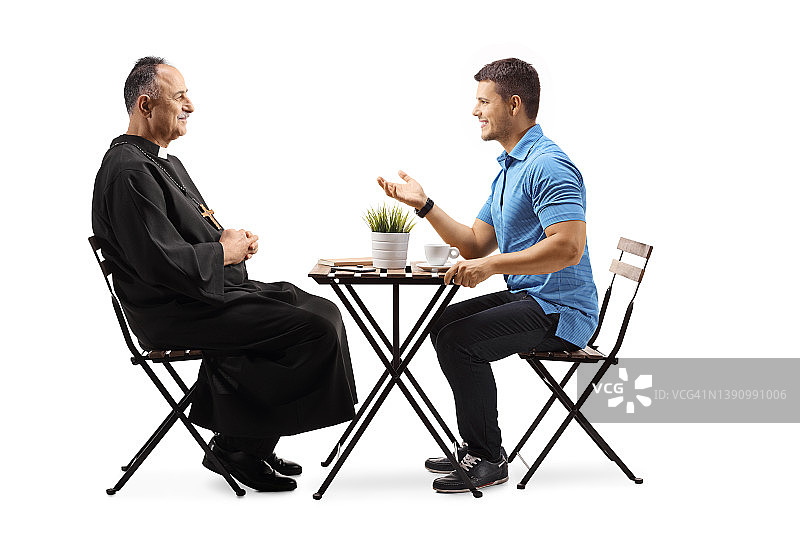 牧师和一个年轻人坐在咖啡桌旁聊天图片素材