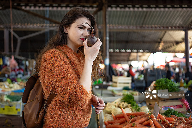 一名年轻女子在当地食品市场购买新鲜水果和蔬菜的照片图片素材
