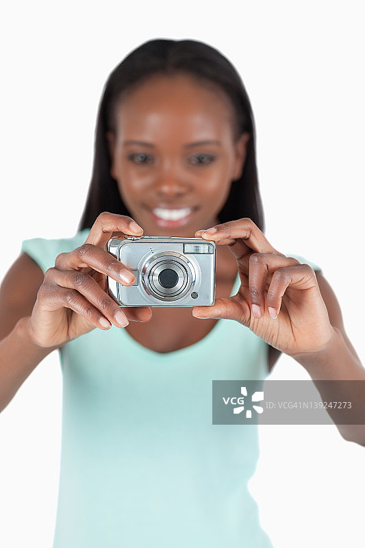 微笑的女人正在使用数码相机图片素材